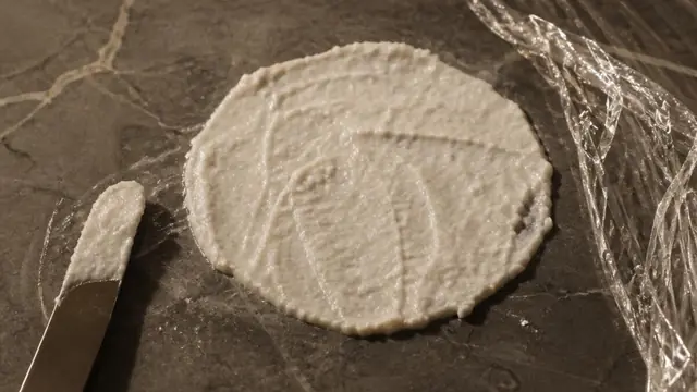 Baking soda poultice treating an oil stain on a marble countertop